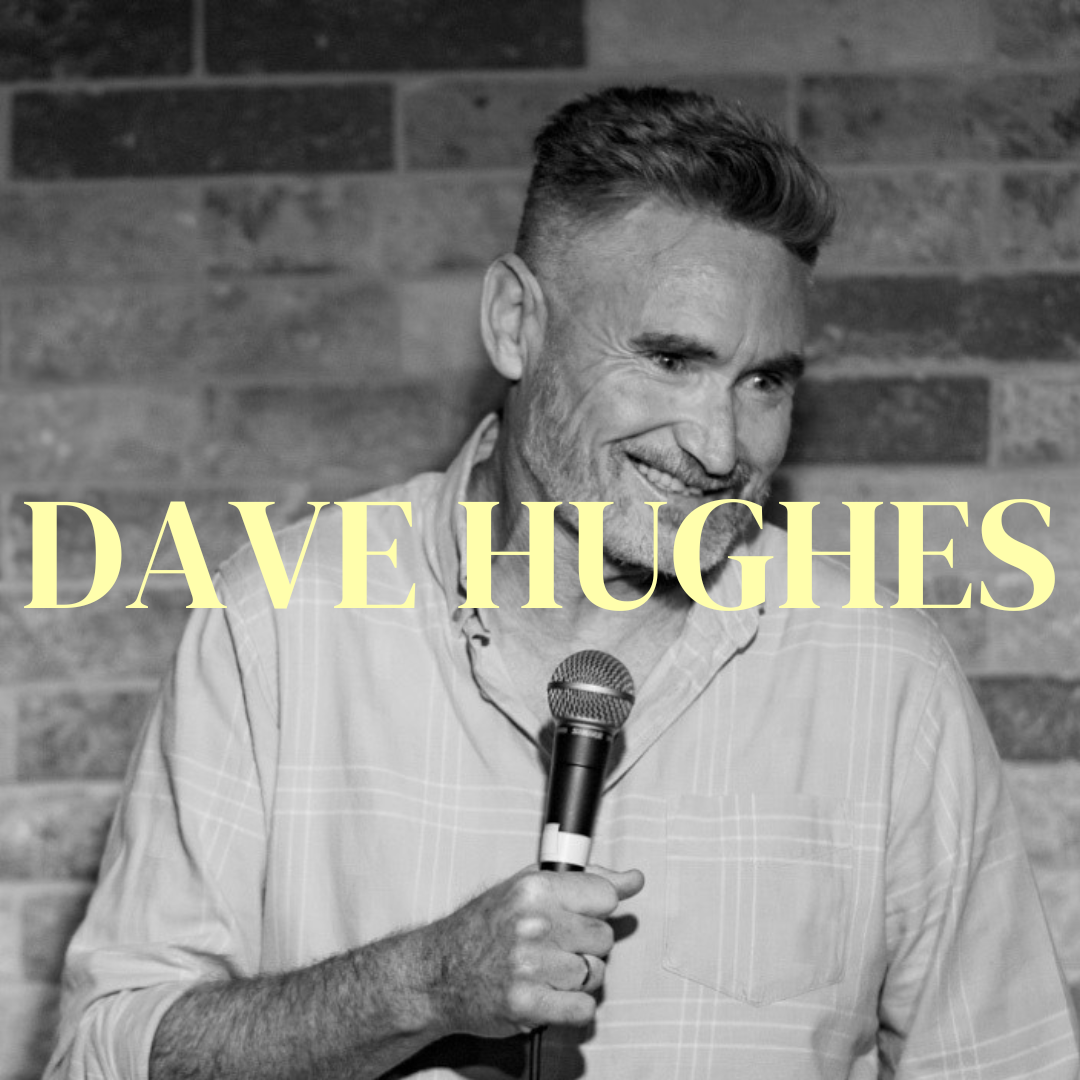 Photo of Dave Hughes smiling with a microphone in hand.